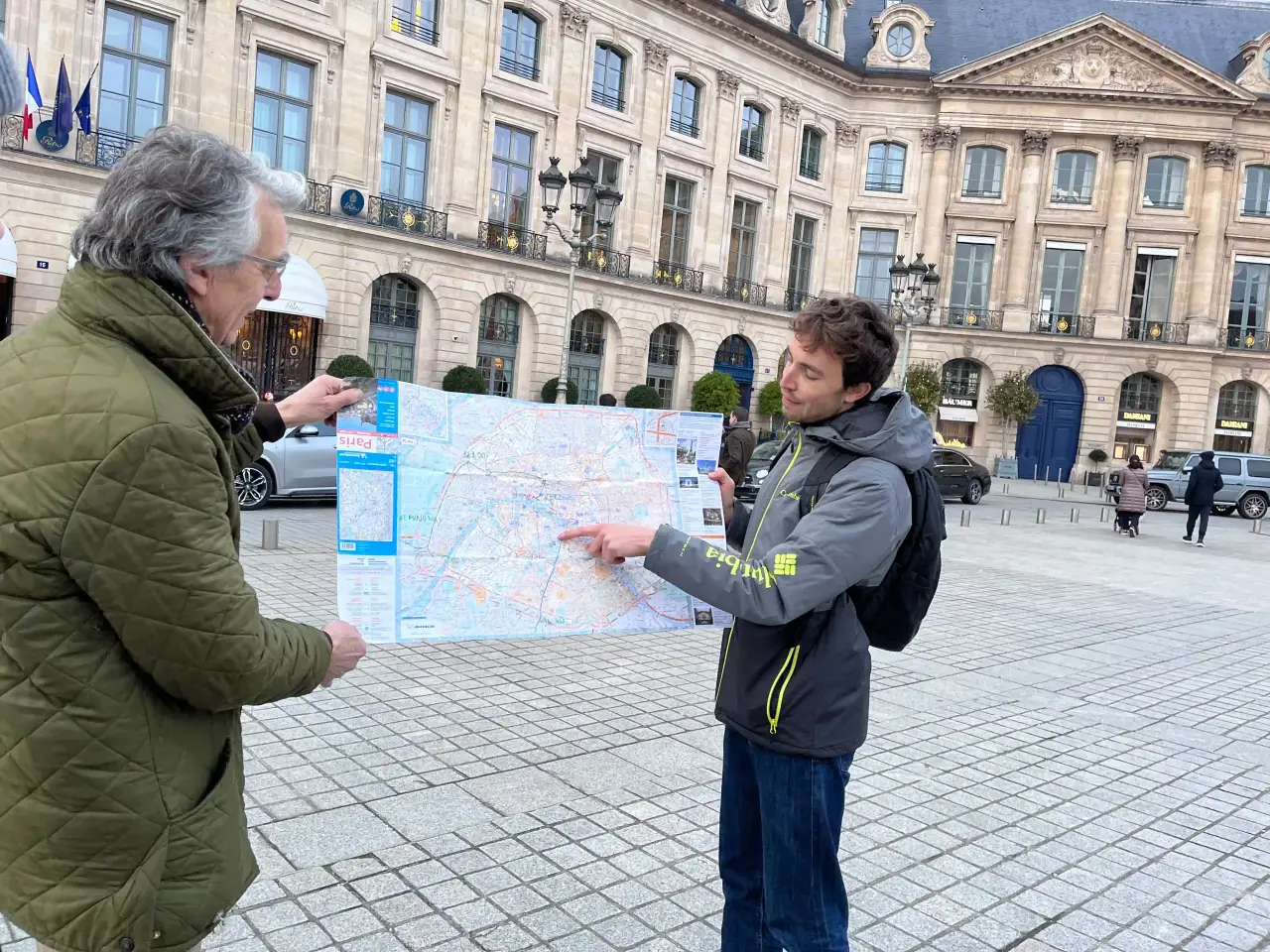 A guide holding a wartime map of Paris on the place Vendôme during a Second World War walking tour