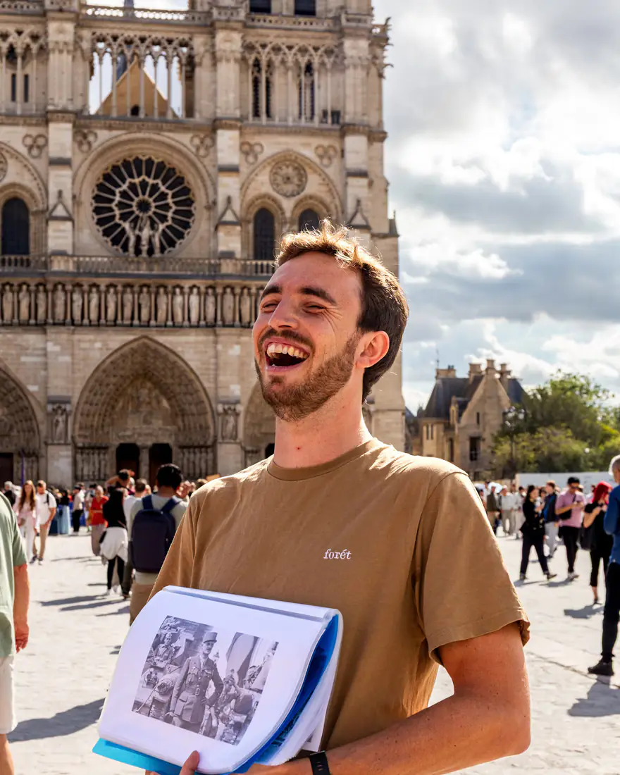 Clément showing a Liberation archive photograph in front of Notre-Dame
